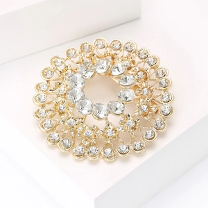 Macro detail of a sparkling rhinestone circular brooch with elegant gold plating structure