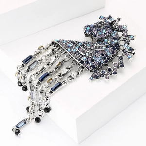 Macro shot of vintage silver horse head brooch with blue crystals and long tassels