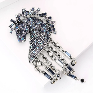 Detailed view of vintage horse head brooch with navy rhinestones and long tassel chains