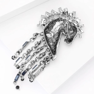 Detail of vintage horse head brooch with silver tassels and blue crystal stones