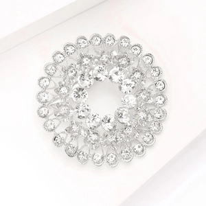 Macro shot of silver-tone circular wreath brooch with shimmering clear rhinestones