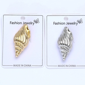 Detailed view of conch shell brooches in gold and silver finish on display cards