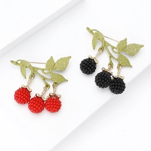 Elegant enamel blackberry and raspberry fruit brooches with gold leaves on white background