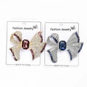 Detailed macro view of bowknot brooches with crystals and large center gemstones