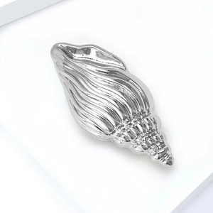 Polished silver conch shell brooch with minimalist metal spiral texture and glossy finish