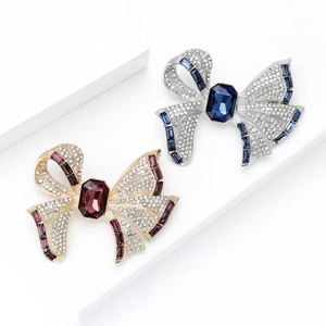 Luxurious bow brooches with sparkling crystals and colored gems in gold and silver finish