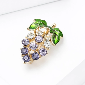 Macro detail of grape brooch with purple crystals and green enamel leaves