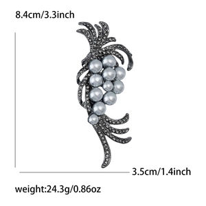Detail shot of elegant leaf-shaped brooch with grey pearls and pavé rhinestones
