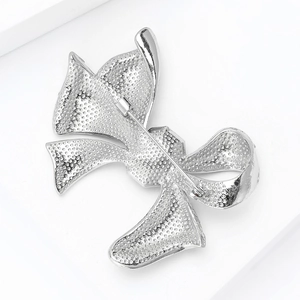 Detailed back view showing the metal pin and textured finish of the bow brooch