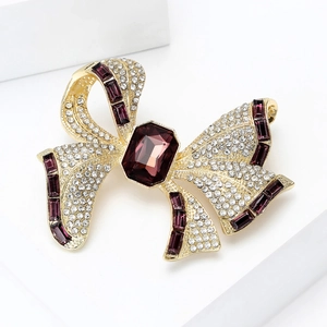 Close-up of luxury bow brooch featuring purple amethysts and sparkling white crystals