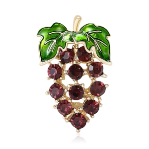 Elegant gold grape brooch with purple crystals and green leaves on white background