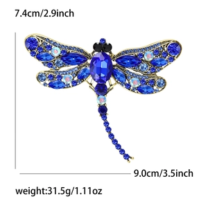 Detailed view of blue dragonfly brooch with vintage gold frame and size markings