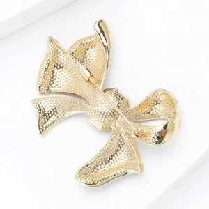 Back view of luxury gold bow brooch showing matte texture and pin closure mechanism
