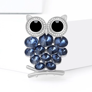Fonkelende uil-broche met blauwe kristallen op zilveren tak, modieus sieraad accessoire