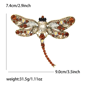 Detailed view of vintage dragonfly brooch with size specs and rhinestone embellishments