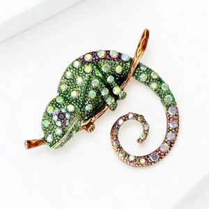 Détail d'une broche caméléon en émail vert émeraude avec des cristaux colorés