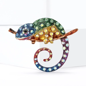 Broche caméléon avec détails en émail et cristaux colorés sur une branche en bois