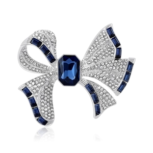 Elegant silver bow brooch featuring a navy blue crystal and white rhinestones