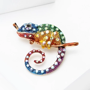 Détail de la broche caméléon avec strass colorés sur une branche en émail brun