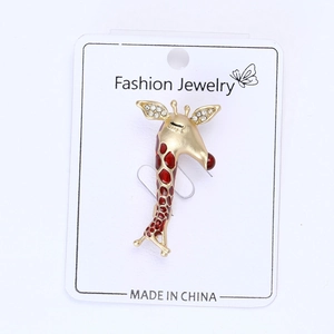 Detailansicht der Giraffen-Brosche mit roter Emaille und Strass auf einer Karte