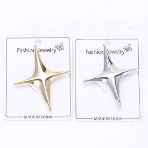 Detailed macro view of gold and silver minimalist star brooches on jewelry display cards