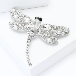 Detail of dragonfly brooch featuring a large oval crystal and pavé rhinestones on wings