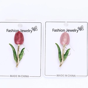 Detail of red and pink enamel tulip brooches with crystal inlay on a display card