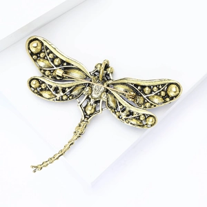 Detailed back view of vintage gold dragonfly brooch showing secure safety pin clasp and texture