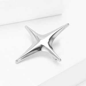 Polished silver four-pointed star brooch with a smooth mirror finish and safety pin