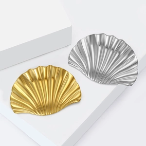 Elegant gold and silver shell-shaped jewelry trays with radial metallic texture on white stand
