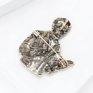Vintage gold plated brooch back view showing secure safety pin clasp and textured metal alloy