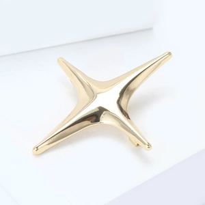Polished gold four-pointed star brooch showing the smooth metallic mirror surface
