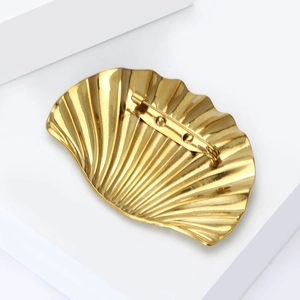 Elegant gold shell-shaped stainless steel brooch with textured radial surface details