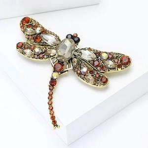 Detailed view of vintage dragonfly brooch with multicolored gemstones on a gold base