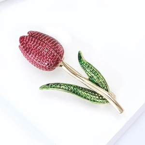 Elegant tulip brooch with red enamel petals and golden stem on white background