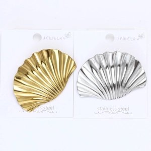 Detailed view of shell-shaped stainless steel brooches in gold and silver finish