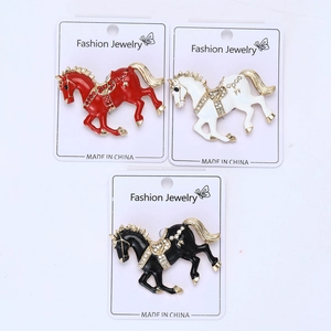 Detailed close-up of three enamel horse brooches with sparkling crystal rhinestones