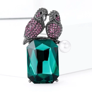 Chic parrot brooch featuring pink crystals, green emerald-cut gem and a white pearl