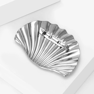 Detail view showing the pin fastening mechanism on the back of the shell-shaped silver brooch