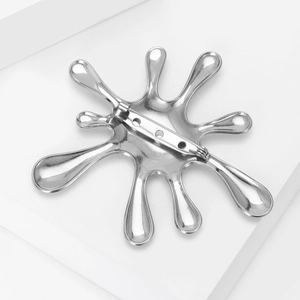 Macro detail of the liquid metal spray brooch back with secure silver safety pin
