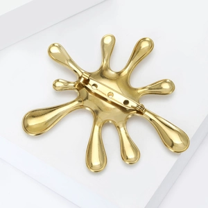 Back view of a gold splash-shaped stainless steel brooch with a secure metal safety pin
