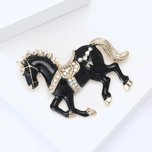 Elegant horse brooch with black enamel, gold trim and sparkling rhinestones on display