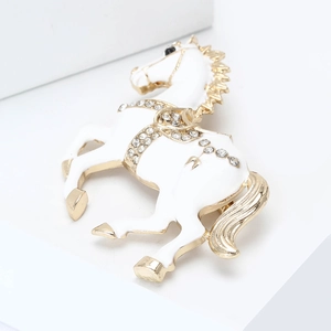 Detail of white enamel horse brooch with sparkling rhinestones and gold-plated edges