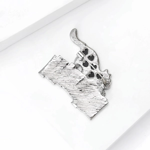 Broche chat minimaliste vue arrière montrant l'épingle de sûreté et le métal brossé