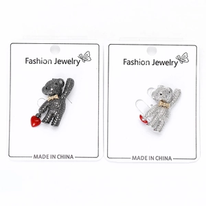 Detail view of rhinestone bear brooches with red heart pendants on card display