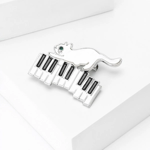 Vue détaillée de la broche émail chat et piano avec placage argent et yeux en pierre verte