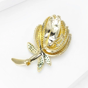 Broche tulpe créative en or avec strass scintillants et gemmes vertes sur fond blanc