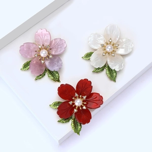 Elegant cherry blossom brooches with pearls and crystals in pink, white, and red colors