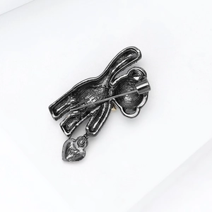 Detail view of the gun-black metal bear brooch pin back mechanism and heart pendant
