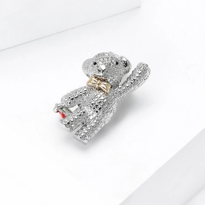 Macro shot of silver teddy bear brooch with sparkling rhinestones and red heart charm